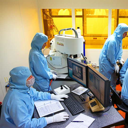 Electron Beam Lithography (EBL) Picture of people in protective laboratory clothing at the workplace of an electron beam lithography system from Raith