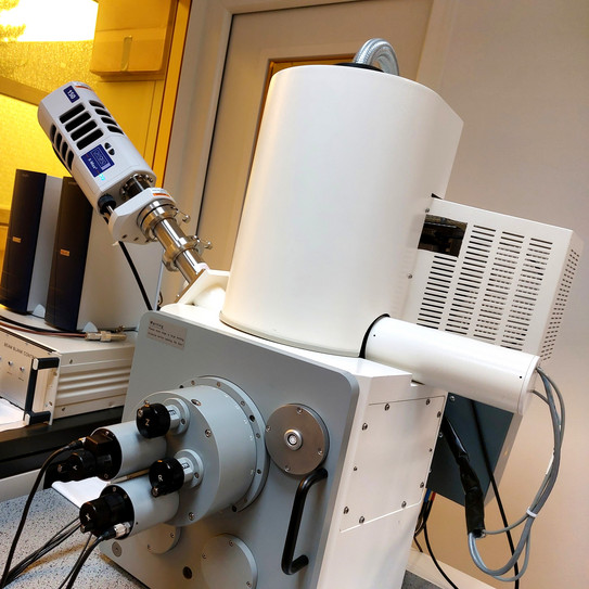Foto im Reinraum mit gelb folierten Fenstern und einem Laborgerät "Zeiss-LEO 982" im Vordergrund